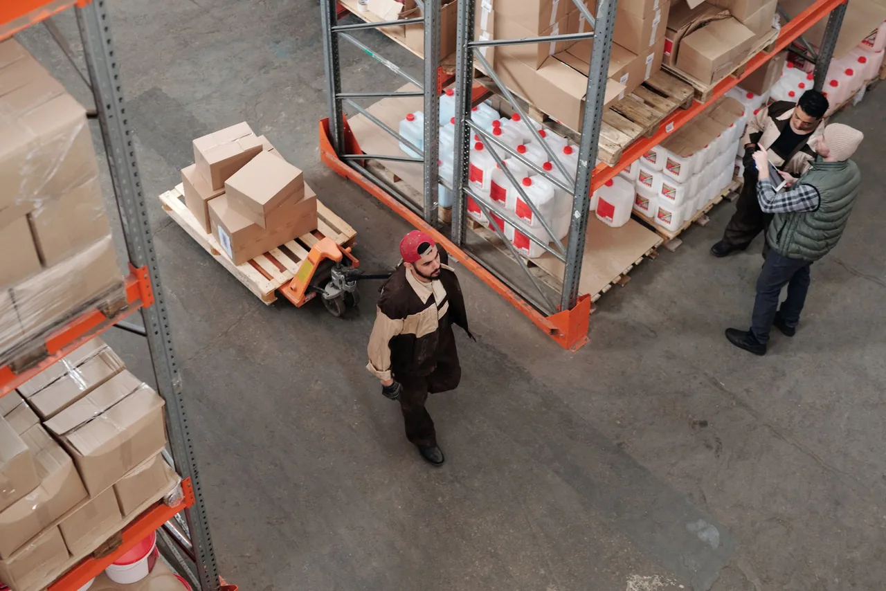 Warehouse team working together among freight shelves